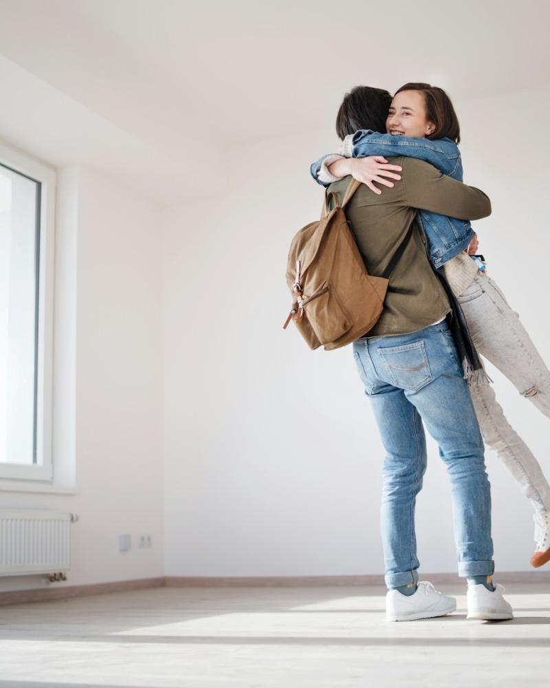 A happy couple embracing in their new home, celebrating a successful relocation.