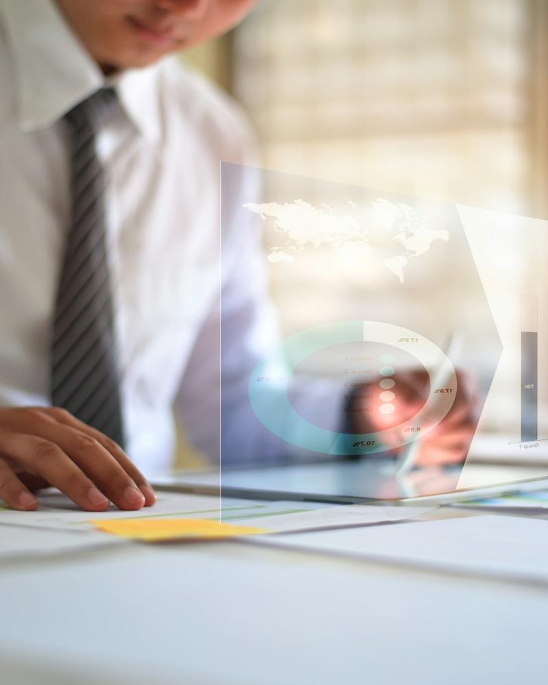 A professional reviewing market reports and financial charts to analyze commercial real estate trends.