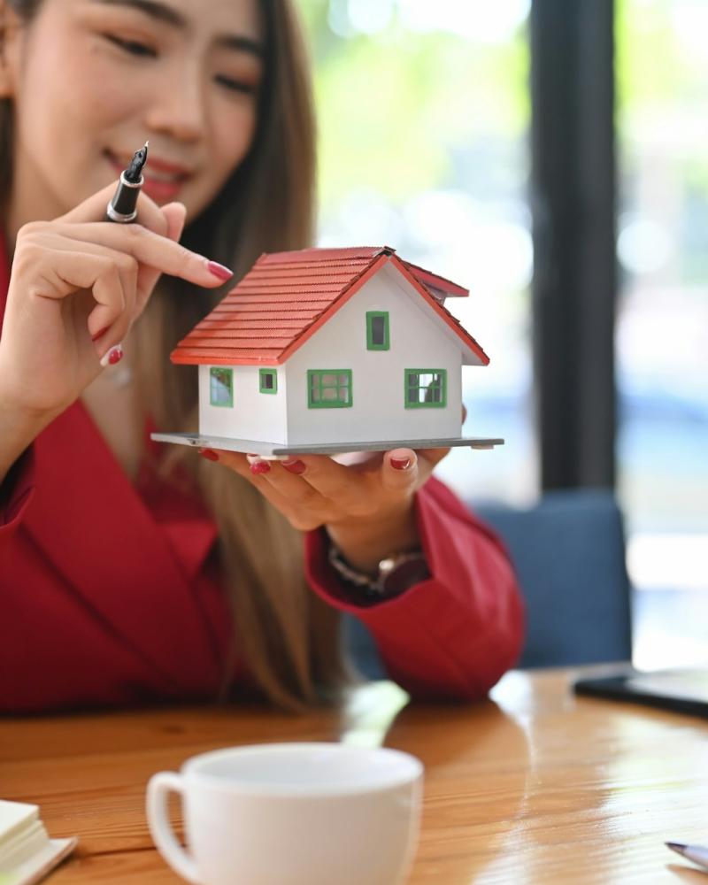 Real Estate Agent Presenting a Miniature House Model to a Client