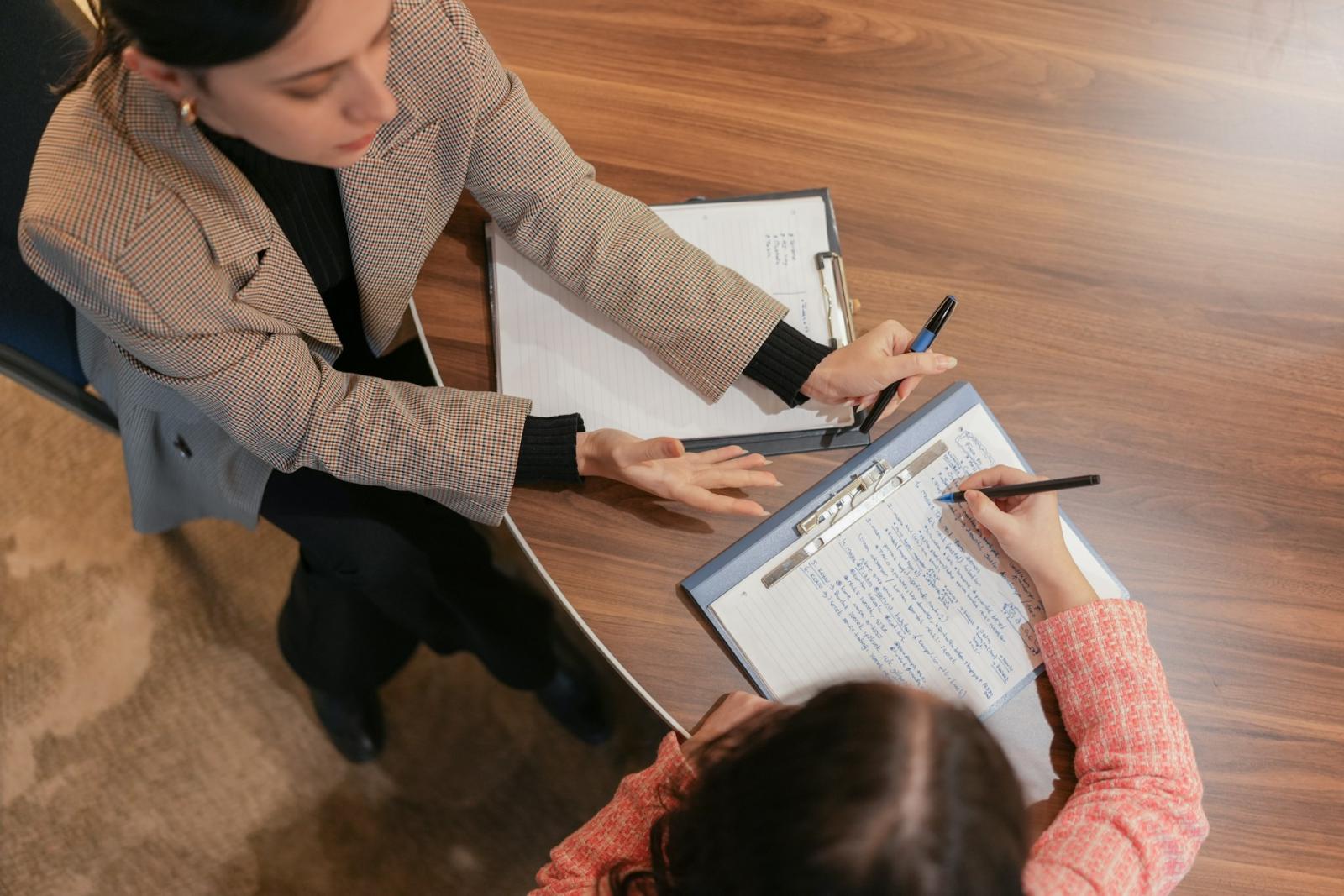 Two professionals reviewing financial documents and investment plans at a wooden table.