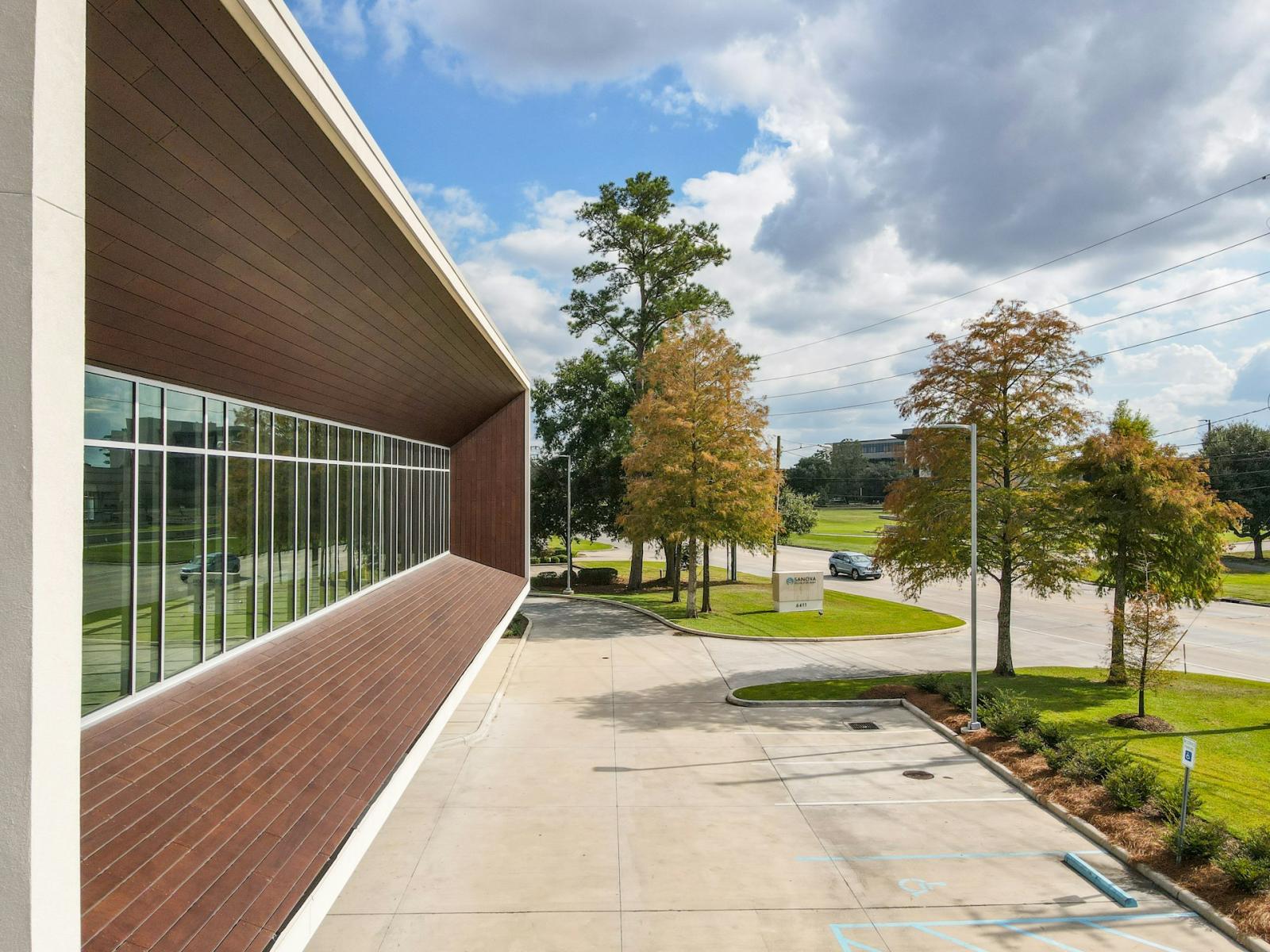 A contemporary commercial office space with large windows, surrounded by a landscaped environment, representing corporate leasing and office real estate solutions.
