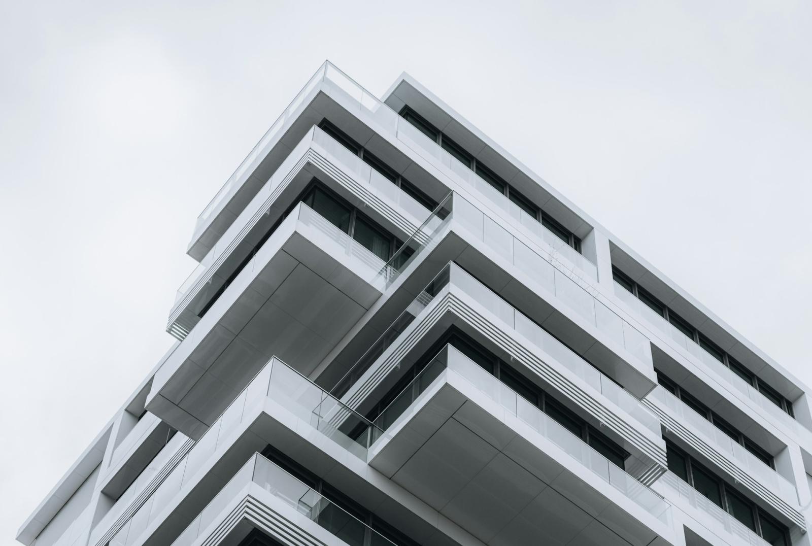 A contemporary, high-rise residential building with glass balconies and modern architecture.